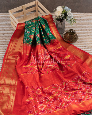 Dark Green Ikkat Patola saree with kanchi border - and a contemporary puff sleeves blouse