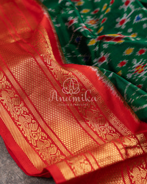 Dark Green Ikkat Patola saree with kanchi border - and a contemporary puff sleeves blouse