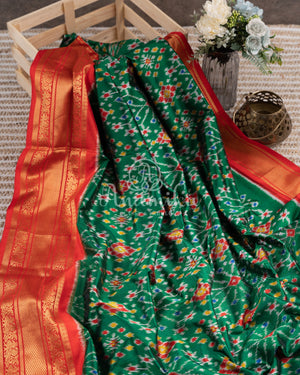 Dark Green Ikkat Patola saree with kanchi border - and a contemporary puff sleeves blouse