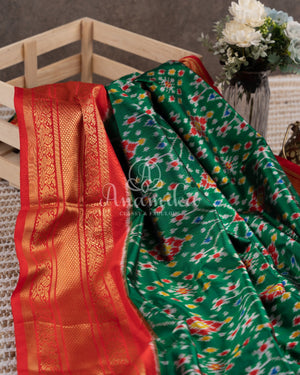 Dark Green Ikkat Patola saree with kanchi border - and a contemporary puff sleeves blouse