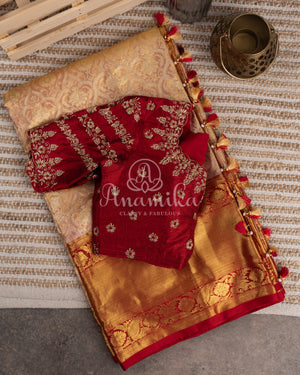 A pure kanjeevaram tissue saree with a contrast maroonish red color heavy work blouse