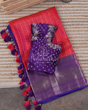 Reddish Pink Kanchipattu saree with a contrast purple blouse