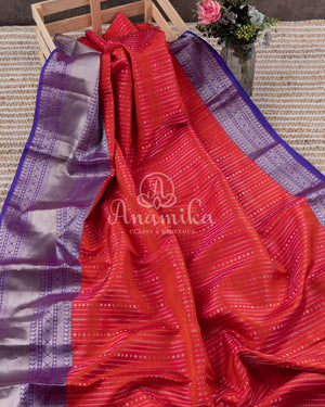 Reddish Pink Kanchipattu saree with a contrast purple blouse