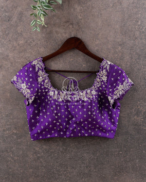 Reddish Pink Kanchipattu saree with a contrast purple blouse