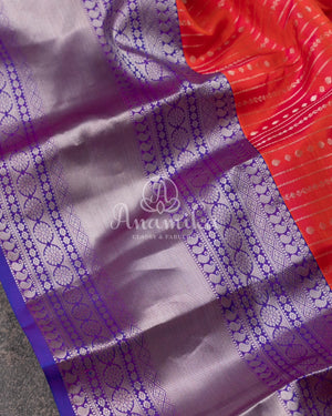 Reddish Pink Kanchipattu saree with a contrast purple blouse