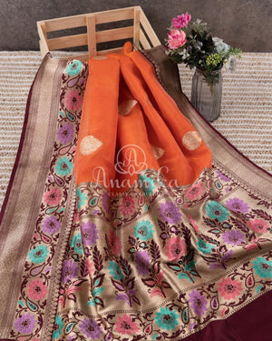 Orange Banarasi Kora Saree with meenakari floral border paired with a contrast brown blouse